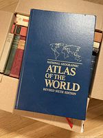 Top view of the National Geographic Atlas of the World in blue with gold lettering.