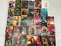 Photo showing a broad assortment of 30 Marvel Masterpieces comic cards arranged in rows on a white surface.
