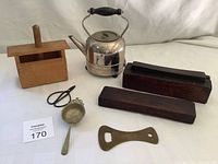 Full lot overview showing wooden butter mold, metal kettle, bottle opener, scissors, and oil stone sharpener