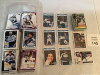 Plastic container with several stacks of hockey cards mostly showing players from the Toronto Maple Leafs and other teams, including some cards partially visible with player images.