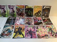 Fifteen X-Men Astonishing comic books laid out on a white surface showing various cover arts.