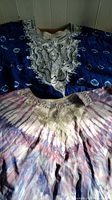 Both dresses laid flat showing full embroidery and tie-dye pattern