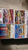 Four vintage car-themed 750-piece puzzle boxes displayed on floor, featuring nostalgic scenes with signage and classic cars.