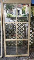 Full view of one antique wood window showing six glass panels and wooden frame.