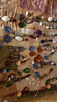 Full view of various jewelry pieces with a range of colors and stones laid on a quilted background