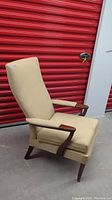 Full side view of beige Mid Century Modern armchair with wood accents showing reclined back and seat cushion.