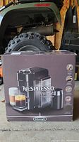 Front side of the DeLonghi Nespresso Vertuo coffee maker box showing the image of the coffee maker and its features.