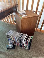 Overview of the speakers, CDs stacked on CD racks, and the wood stand near a railing by a table