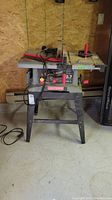 Front view of Sears Craftsman 10-inch table saw on metal frame in garage space