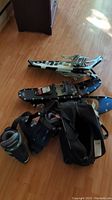 Two pairs of 30" snowshoes, ski boots and carry bag arranged on floor
