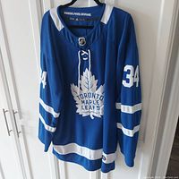 Front view of blue Toronto Maple Leafs jersey with number 34 and logo.
