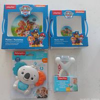 Photo showing Playtex Paw Patrol plates and bowls in original packaging, along with Fisher-Price Teether Tunes Koala and Rock 'n Rattle Teether Ring in original packaging.