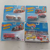 Four Hot Wheels diecast items new in original packaging: three Track Stars vehicles and the Planet Micro Urban Rescue set.
