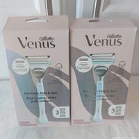 Front view of two Gillette Venus razor boxes, showing packaging information including intended use for pubic hair and skin and irritation defense bar feature