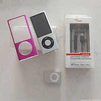 Apple iPod Nano 8GB, pink colored skin case, Apple iPod Shuffle, and Fuse lightning earbuds in packaging