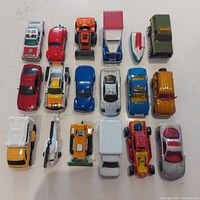 Top down view of all 18 Matchbox vehicles arranged in rows showing various models and colors.
