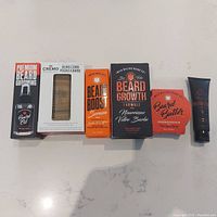 Full lot of men's beard maintenance products arranged in a row showing the packaging and variety.