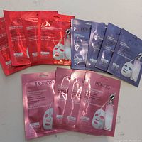 All 12 Pond's serum face masks grouped by type in their sealed foil packets: 4 Brightening Serum Masks (pink), 4 Firming Serum Masks (purple), 4 Wrinkle Correcting Serum Masks (red).