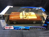 Side front view of 1:18 scale model car in original Maisto box showing copper metallic paint and convertible interior.