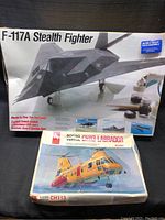 Two model plane kits, one sealed and one open, showing box art and sizes