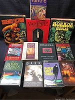 Overview of all 14 books in the lot arranged on a surface showing the various titles and cover art related to horror and science fiction.