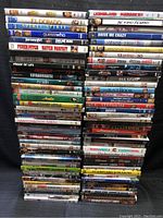 Photo showing multiple stacks of DVD movies with visible titles including El Dorado, License to Wed, Spirit Streak Extreme Team, Fever Pitch, Match Point, 13 Going on 30 among others.