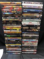 Stacked DVDs showing spines with titles across various genres and conditions.