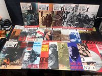 Flat lay photo showing front covers of all 24 WW2 magazines including titles and cover images.