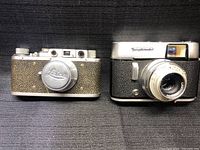 Front view of both cameras side by side on black background