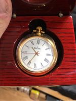 Close-up of Bulova pocket watch in wooden presentation box.