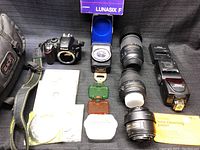Overview of camera body, lenses, flash, light meter, filters, cleaning paper and bag