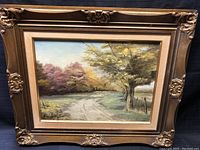 Full view of oil painting in ornate wooden frame, showing autumn tree landscape and dirt path.