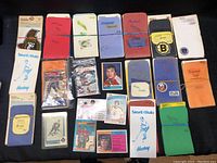 Full set of hockey card bundles placed on a black surface, showing multiple rubber-banded stacks with handwritten labels indicating different NHL teams from the 1970s and some loose cards including a Wayne Gretzky card in poor condition.