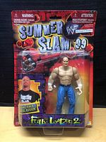 Full front view of Stone Cold Steve Austin action figure in original SummerSlam 99 Fully Loaded 2 packaging with included accessory.