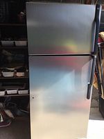 Front view of refrigerator showing stainless steel front doors and overall exterior condition