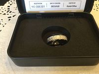 Ring displayed in black presentation box with foam insert, showing meteorite inlay and overall design.