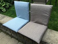 Front view of two portable padded seats showing fabric covering in blue and brown colors and their seating surfaces.