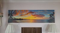 Full front view of the panoramic canvas wall art hanging above a fireplace flanked by two lamps