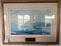 Full view of framed art depicting fishing boats on the water, showing the frame, matting, and print content