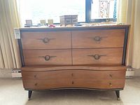 Front view showing four upper drawers and two scalloped lower drawers, metal ring pulls