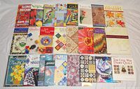 Full set of 24 quilting and fabric craft books arranged in 4 rows, showing colorful covers and titles.