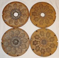 Top view of two round rubber molds with detailed pendant patterns, laid flat showing outer surface and pendant cavities.