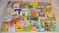 Photo of all 40 children's books arranged on a floor showing variety and condition.