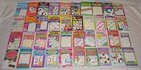 Full view of asorted 40 puzzle books including crossword, sudoku, and word search types laid out in rows on a flat surface.