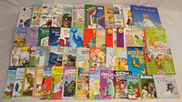 Full overview of 50 children's books including colorful covers with animals, dinosaurs, nature, and fiction titles in a mix of hard and soft covers.