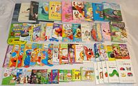 Overview of all 58 children's books laid out on a surface, showing a mix of titles and colorful covers including Sesame Street and Thomas the Tank Engine