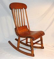 Side view of the antique Little Boston rocker showcasing the armless curved wooden sleigh seat, turned front legs, and rocker base.