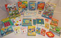 Full view of lot showing 22 kids games in boxes and some loose components arranged on a table