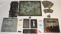 Full layout of game components including board, cards, tokens, box and rulebook.