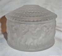 Front angled view of lidded frosted crystal bowl showing children figures sculpted in relief around the bowl.